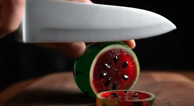 A watermelon cutting by a knife 