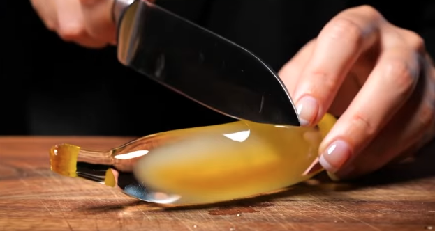 a knife cutting a banana made of glass.