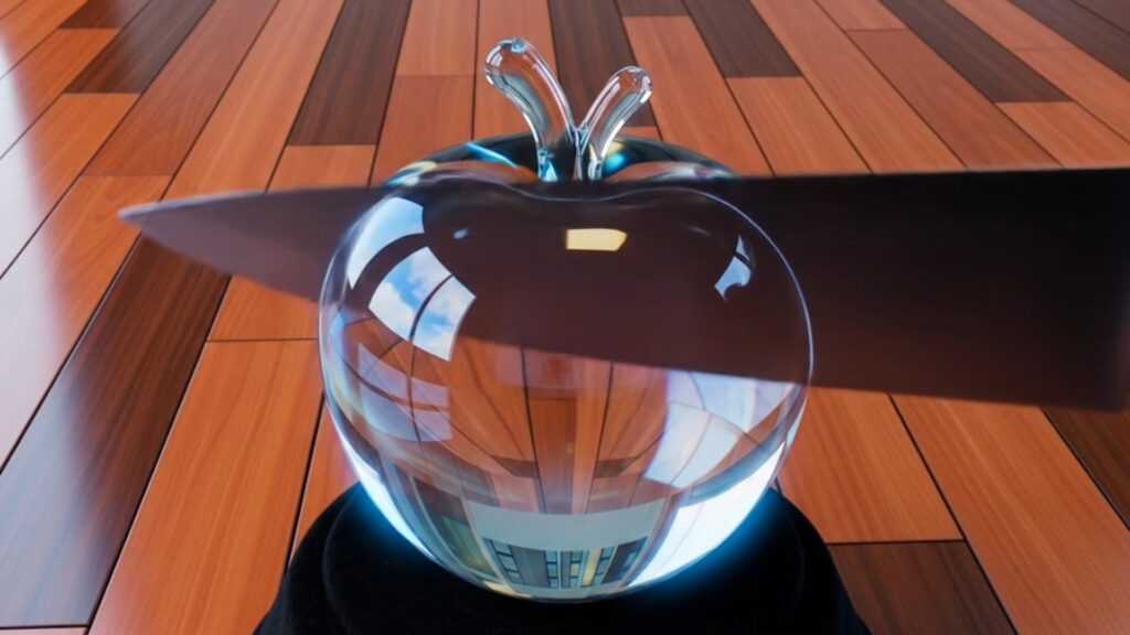 a shiny glass apple cutting by a knife.
